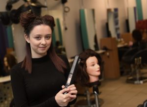Hairdressing Student Styling Hair on Block Head