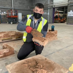 Jamie Turner - construction and plant operations student laying bricks