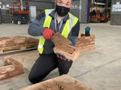 Jamie Turner - construction and plant operations student laying bricks