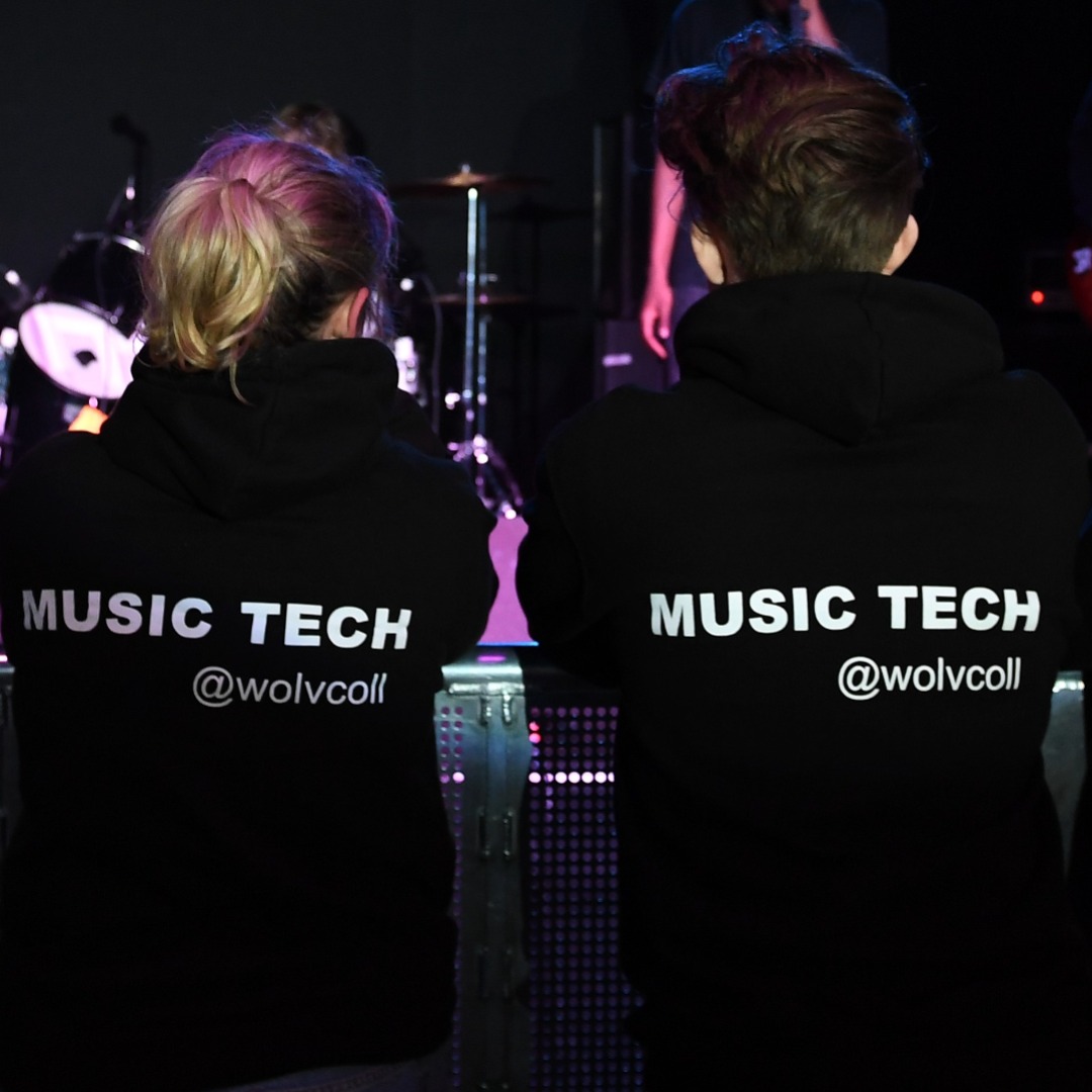 Two music technology students watching a performance