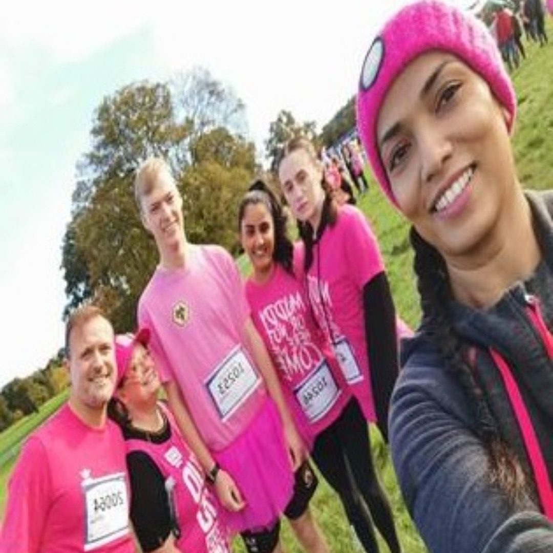 Six members of staff - four female and two male in pink t-shirts and black leggings before the start of the charity fun run