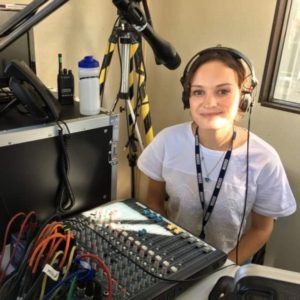 Fomer NCTJ student Francesca Price, wearing headphones in the studio at NNC Radio Shropshire