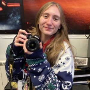 Photography student Rhiannon Cooper holding a camera in the photography studio