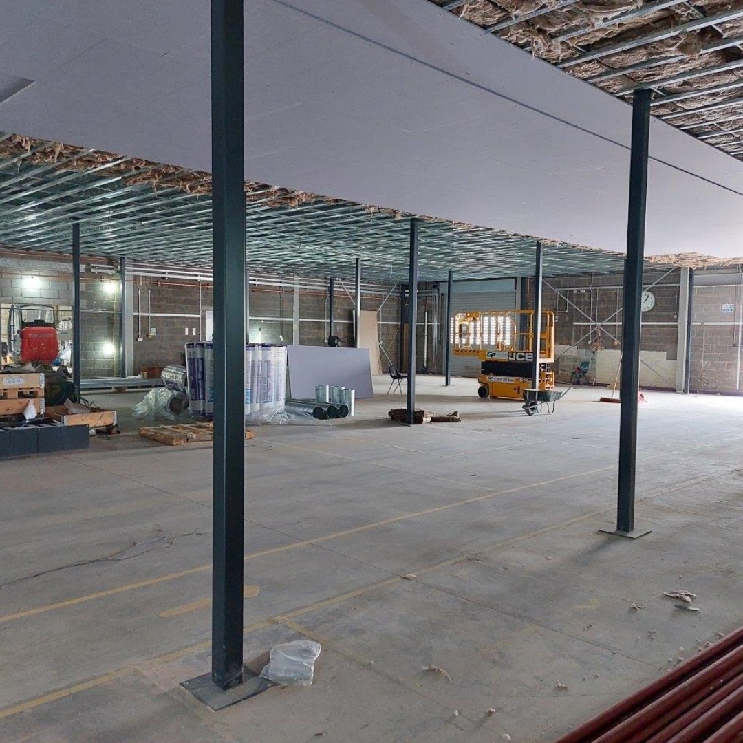 Construction of a new mezzanine area in the construction block at the Wellington Road campus - picture shows metal props holding holding up the floor with equipment in the backgrouns