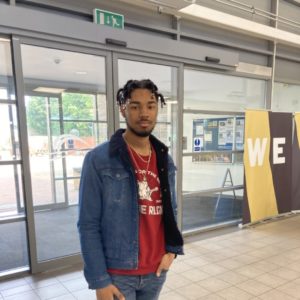 STudent SHaquile Barnaby wearing a read t-shirt and a denim jacket