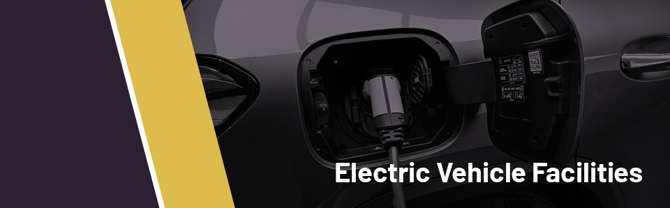 Grey banner with mustard diagonal stripe and the words Electric Vehicle Facilities written on the right in white text
