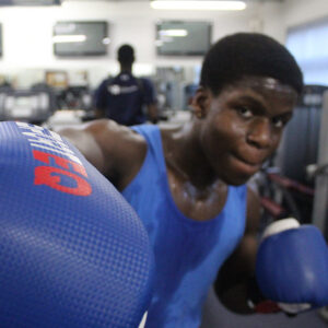 Close up of a teenager wearing a boxing glove in a punching pose