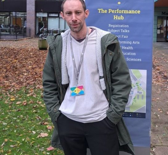 Access to HE student John Toye wearing a whit3ee t0shirt, grey jacket and a University of Wolverhampton lanyard