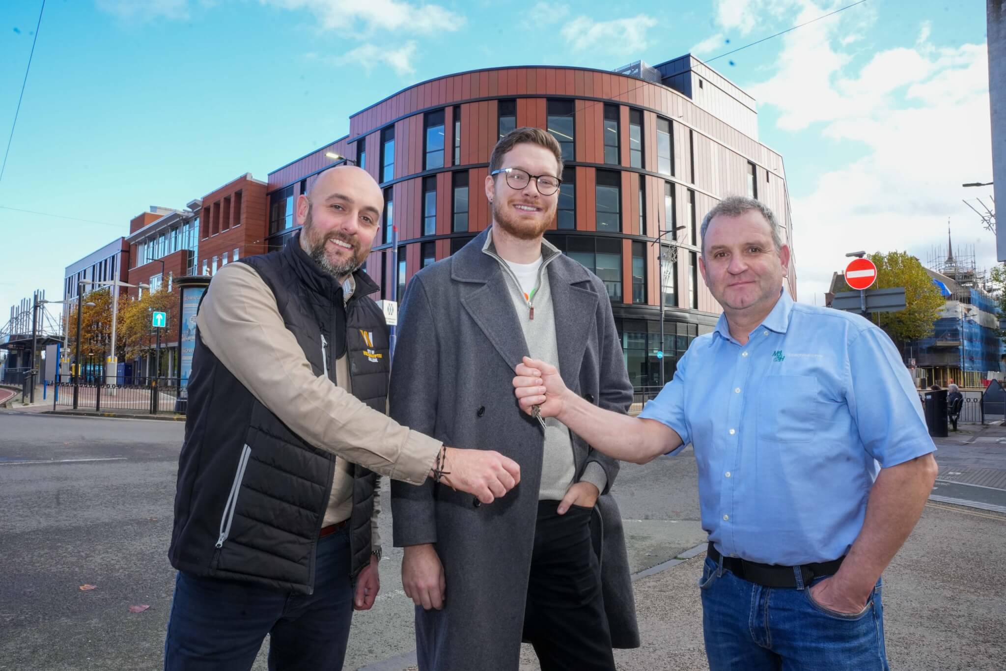 Three staff - from the college, council and contractor, standing outside the new CLQ campus building